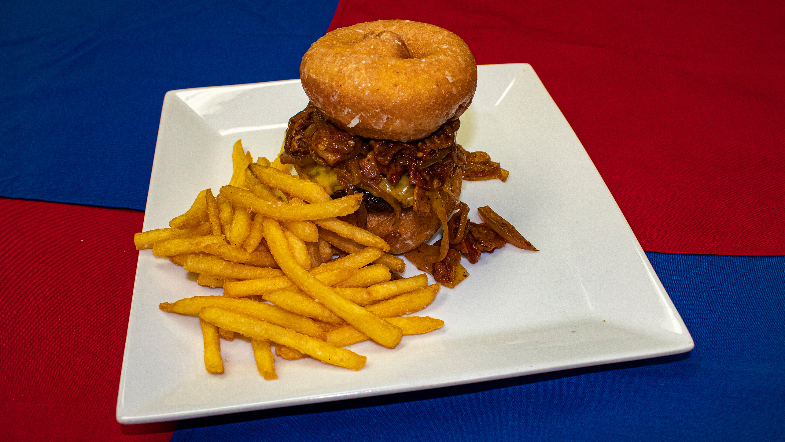 <strong>Double Play Burger</strong> – Grilled hamburger patty topped with American cheese and tomato-bacon jam served between two glazed doughnuts and fries. <em>Submitted by Tim McFeeters</em>