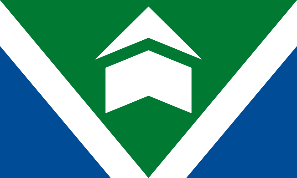 This flag features two diagonal white lines that extend from the top left and right corner to the bottom center of the flag, giving the appearance of the letter v. The upper portion of the flag is green, while the lower portion is blue. The green portion of the flag forms a triangle in the center. Two white shapes in the middle of the green area are similar to the shape of historic Fort Vancouver.