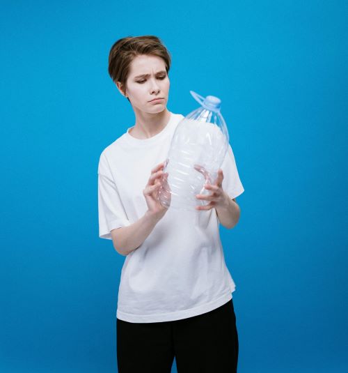 Women in white shirt confused about plastic bottle