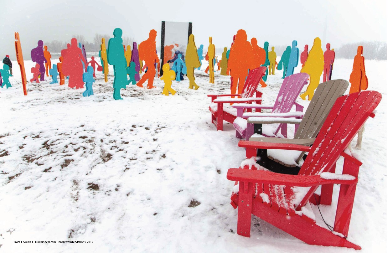  Snowy red and purple chairs face a winter art display of brightly colored human silhouettes. 