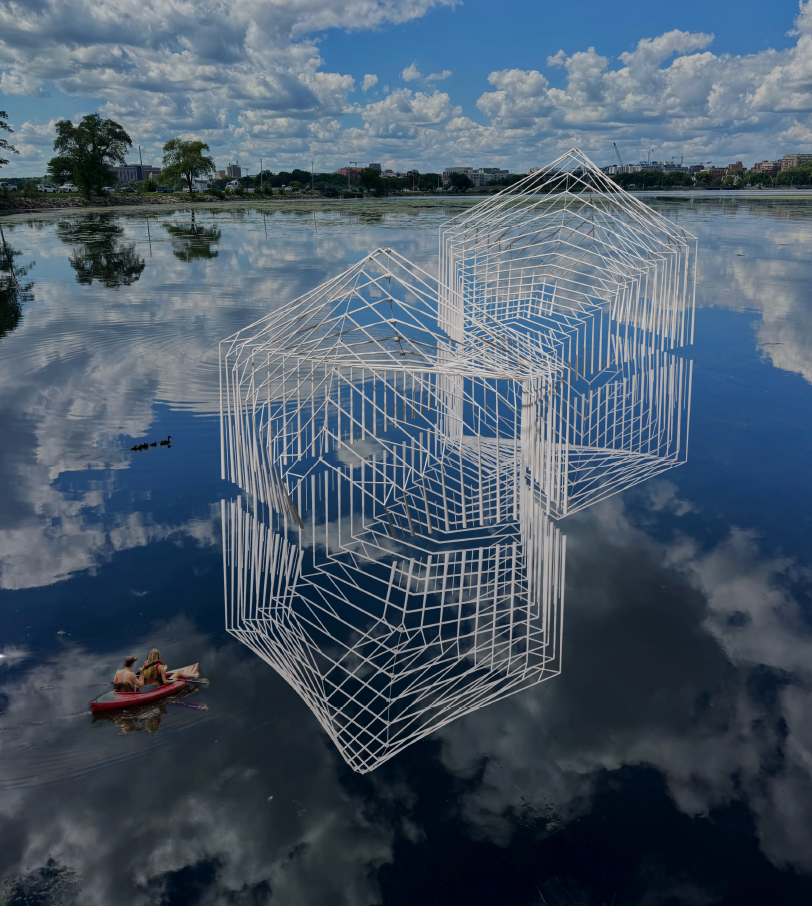 A ribbed sculpture in the shape of a small house on a lake.