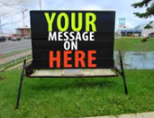 Large sign on a wide metal frame on grass