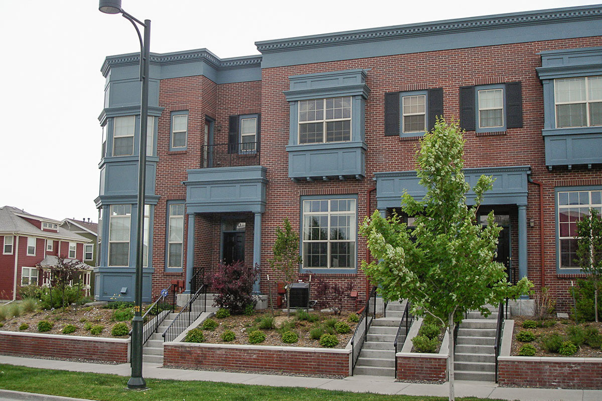 A long brick townhouse with blue accents.
