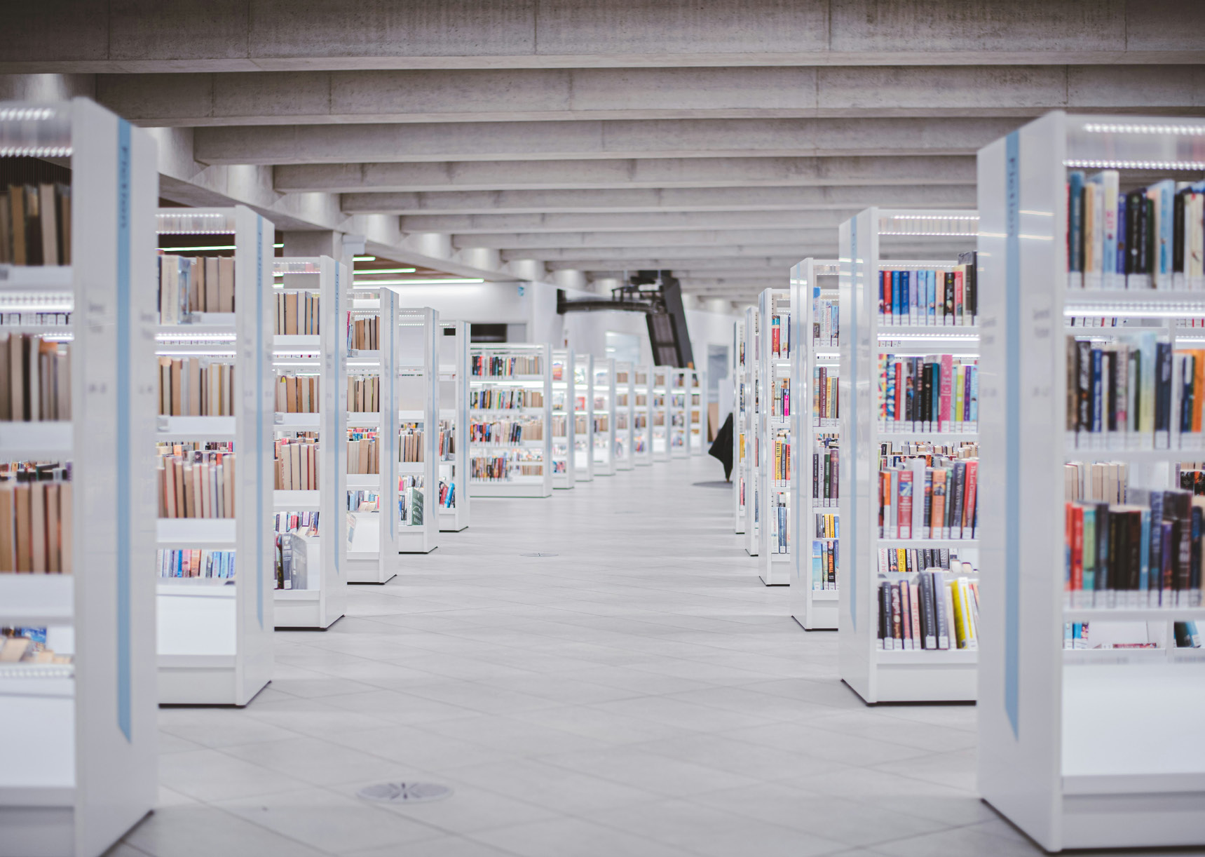 A corridor between two rows of silver, modern library shelves.